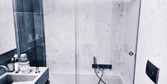 Καμπίνα μπάνιου με ένα σταθερό και ένα συρόμενο τζάμι. Τα τζάμια είναι 10 χιλιοστών SECURIT με υδροφοβική επίστρωση. Οι οδηγοί, τα στηρίγματα και το πόμολο είναι inox